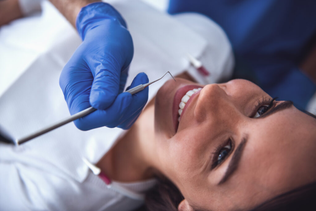 A woman smiles as she receives a dental cleaning-naccid buford dentist