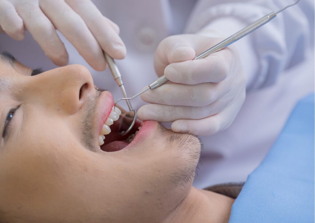 Dentist examining a patient's back molars to monitor wisdom tooth development and determine how long a wisdom tooth may take to come out.