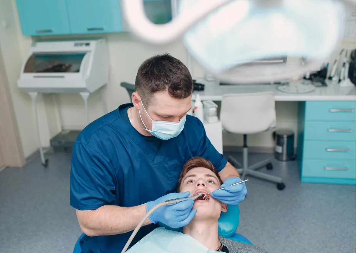 Dentist removing plaque from a patient’s teeth during a professional dental cleaning.