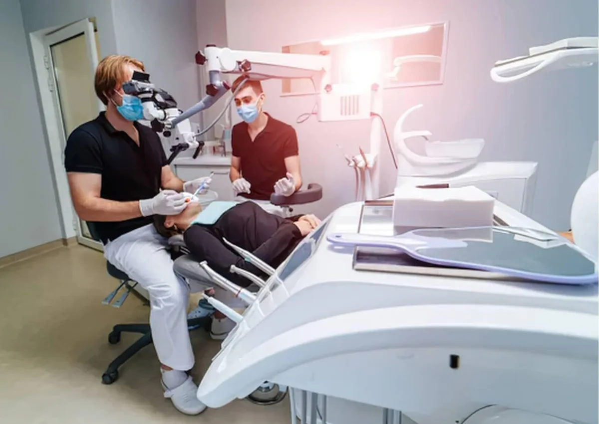Dentists examining a patient’s teeth for signs of cavities and tooth decay during a dental visit.