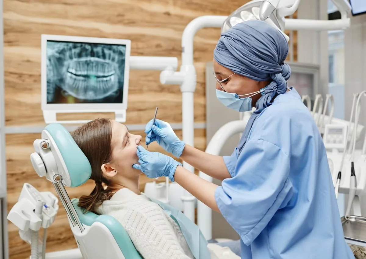 Dentist examining a patient during a consultation about affordable dental implant treatment options.