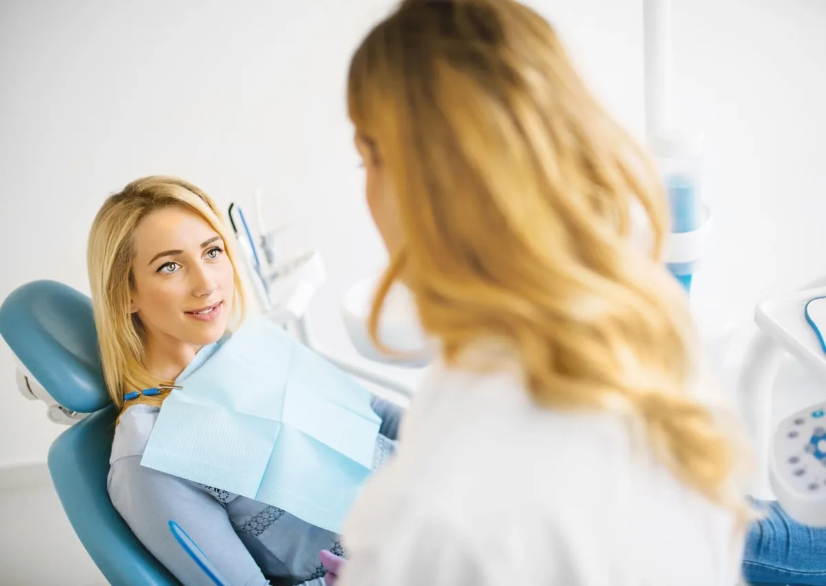 Patient discussing with a dentist how long after fluoride treatment they should wait before eating.