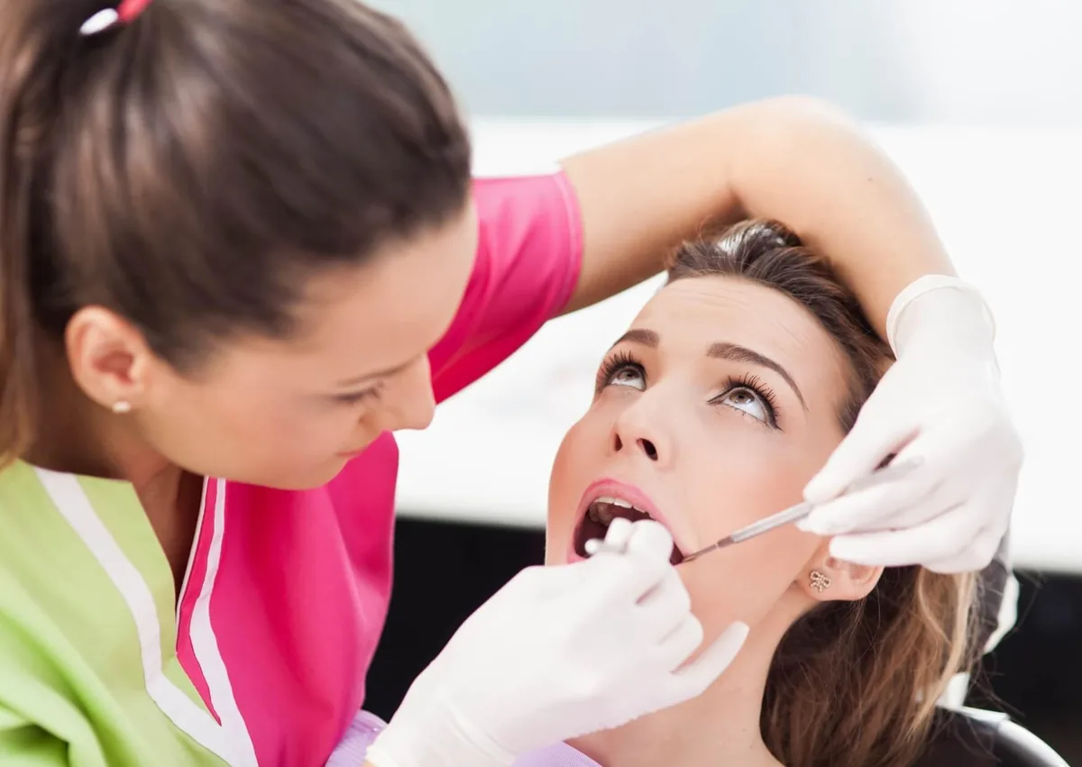Dentist performing a cosmetic dental procedure related to tooth contouring and reshaping.