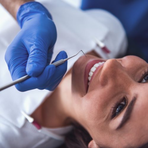 A woman smiles as she receives a dental cleaning-naccid buford dentist