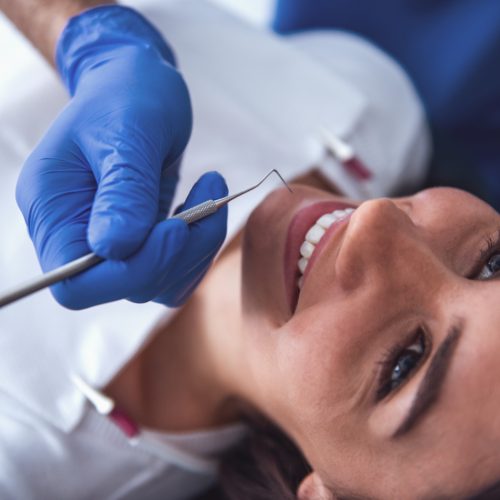 A woman smiles as she receives a dental cleaning-naccid buford dentist
